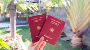 Hand,Holding,Two,German,Passports,In,Front,Of,A,Beautiful